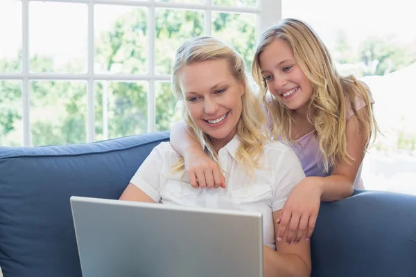 Madre e hija usando laptop en sofá — Foto de Stock