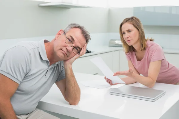 Pareja discutiendo sobre una factura en la cocina — Foto de Stock