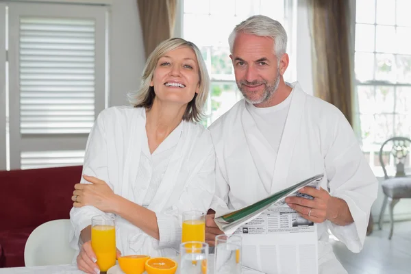 Couple reading newspaper while having breakfast — Stock Photo, Image