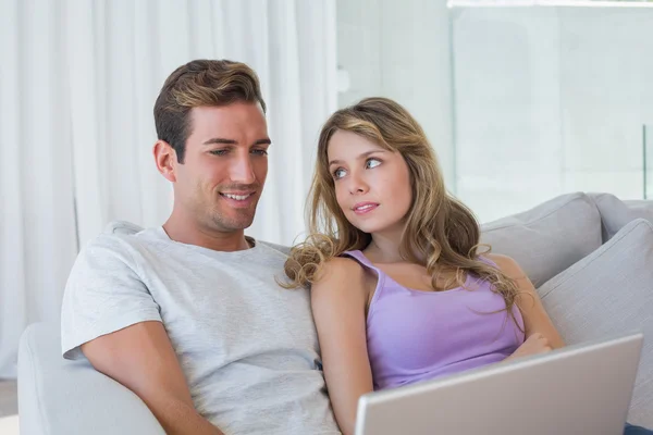 Miłej pary za pomocą laptopa na kanapie — Zdjęcie stockowe