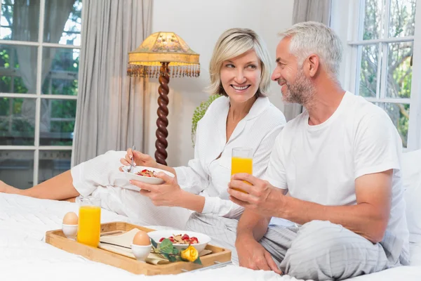 一对成熟的夫妇在床上吃早餐 — 图库照片