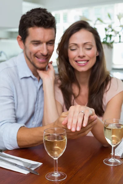Happy woman showing engagement ring besides man — Stock Photo, Image
