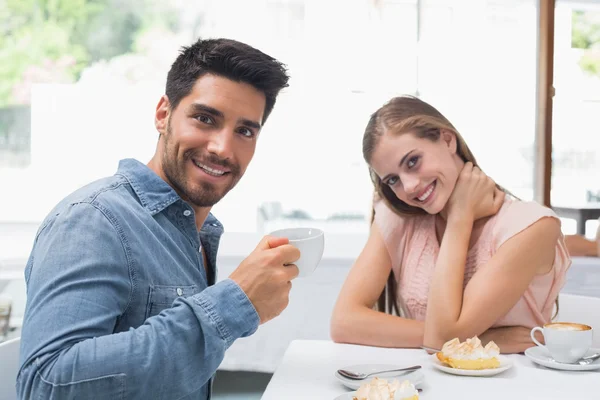 Pareja sonriente tomando café en la cafetería —  Fotos de Stock