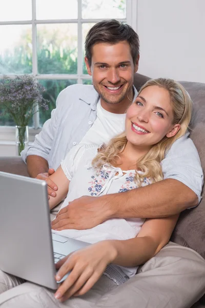 oturma odasında dizüstü kullanarak rahat bir çift portre