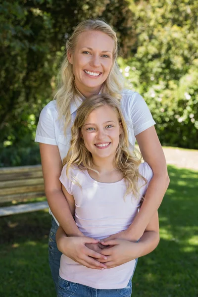 Happy woman embracing girl in park — Stock Photo, Image