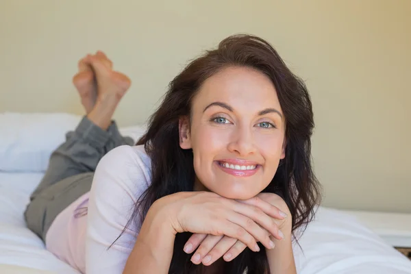 Porträtt av självsäker kvinna ler i sängen — Stockfoto