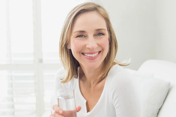 Portret van een vrouw lachende ontspannen met een glas water — Stockfoto