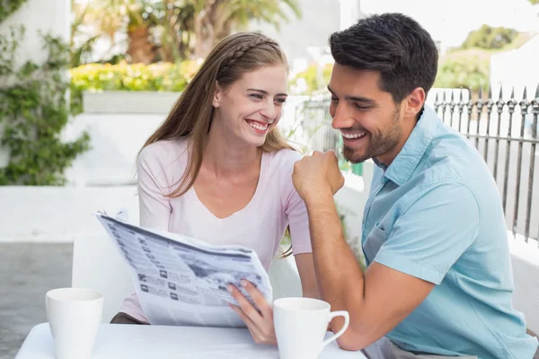 Sorridente coppia lettura giornale al caffè — Foto Stock