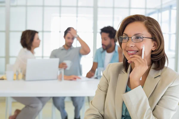 Empresária sorridente com colegas em reunião — Fotografia de Stock