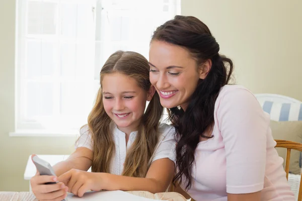Happy mother and daughter using cell phone — Stock Photo, Image