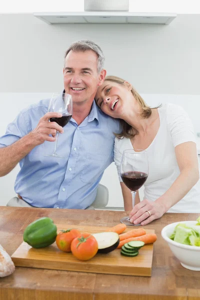 Loving couple with wine glasses in kitchen — Stock Photo, Image
