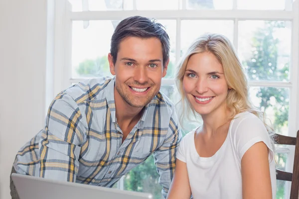 Feliz pareja joven con portátil en casa — Foto de Stock