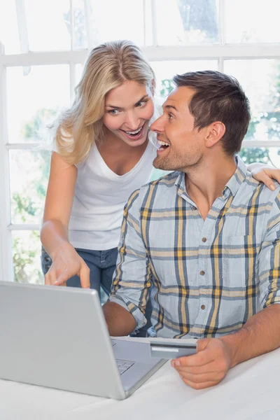 Веселая пара делает покупки в Интернете дома — стоковое фото