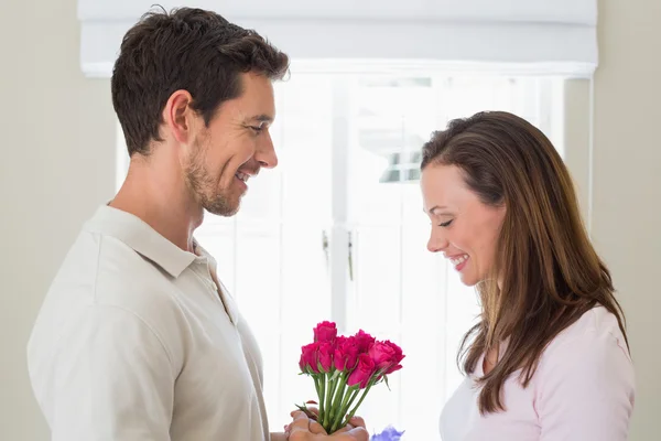 Man giving happy woman flowers at home — Stock Photo, Image