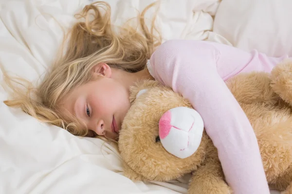 Girl sleeping peacefully with stuffed toy in bed — Stock Photo, Image