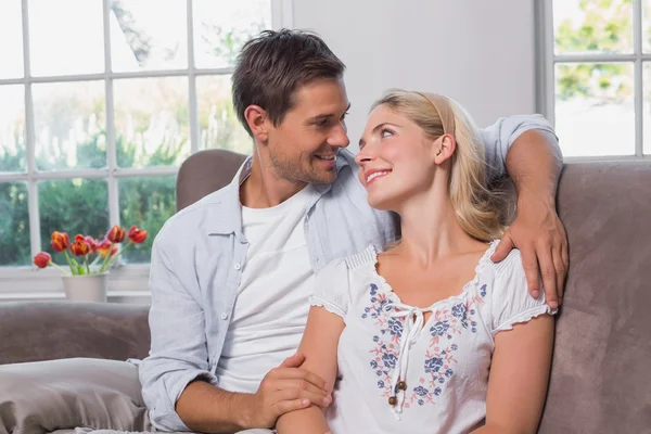 Relaxed loving young couple sitting on sofa — Stock Photo, Image