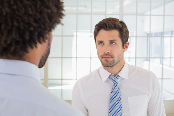 Serious businessmen looking at each other in office — Stock Photo, Image