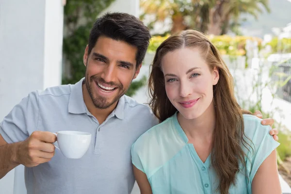 Casal sorridente com xícara de café no café — Fotografia de Stock