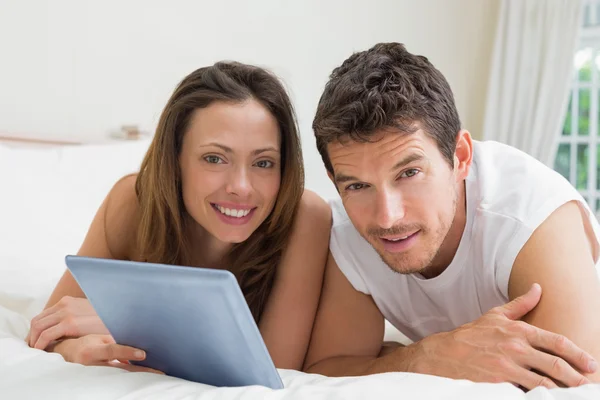 Casal usando tablet digital na cama — Fotografia de Stock