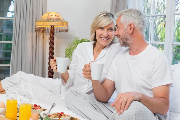 Mature couple having breakfast in bed — Stock Photo, Image