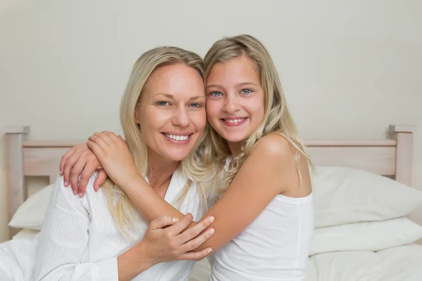 Gelukkig dochter omhelst moeder in bed — Stockfoto