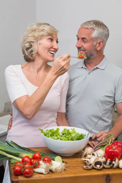 Mutlu bir kadın mutfakta Olgun çift salata besleme — Stok fotoğraf