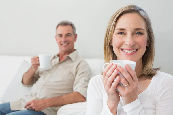 Ontspannen paar met koffie kopjes in woonkamer — Stockfoto