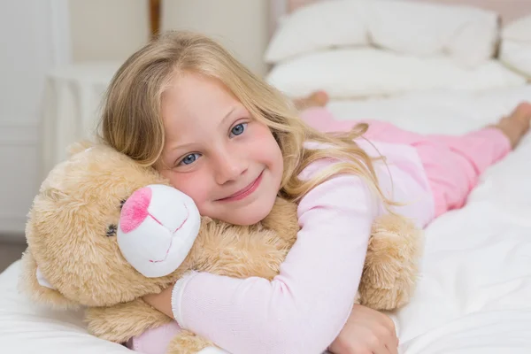 Young girl resting in bed with stuffed toy Royalty Free Stock Images
