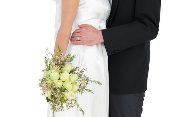 Mid section of bride and groom with rose bouquet Royalty Free Stock Images