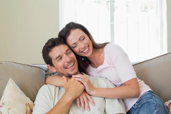 Portrait of a loving couple sitting on couch — Stock Photo, Image
