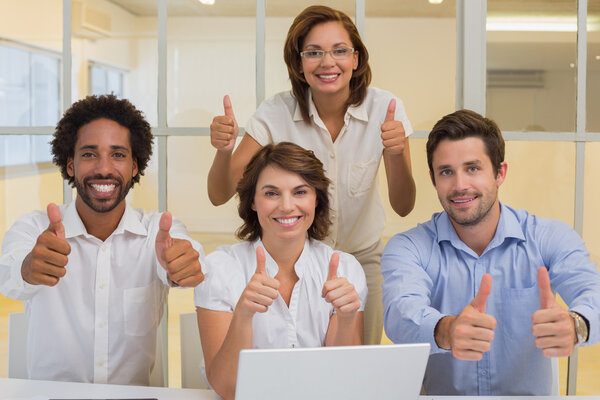 Happy business people gesturing thumbs up at office Royalty Free Stock Photos