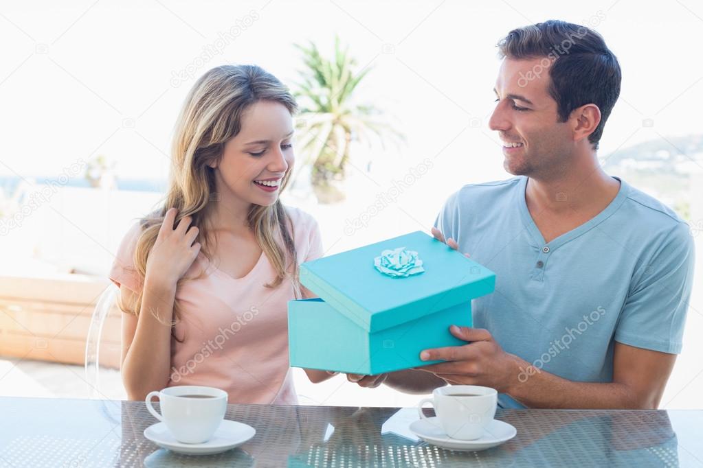 Young man giving happy woman gift box