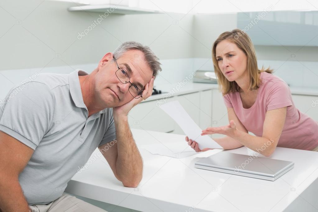 Couple having an argument over a bill in kitchen