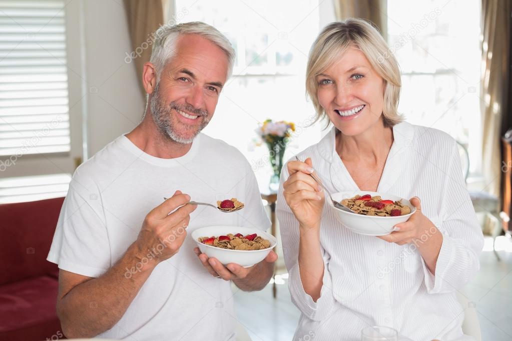 Happy mature couple having breakfast at home