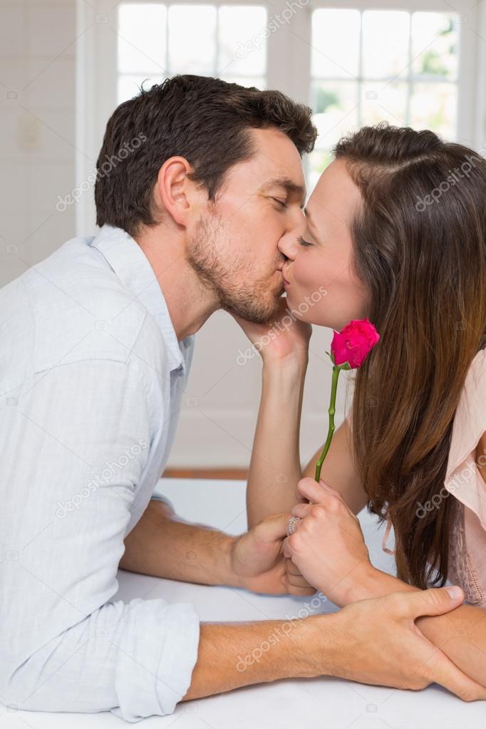 Loving young couple kissing at home