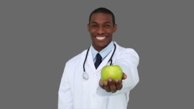 mutlu genç bir doktor bir elma kamera gösterilen