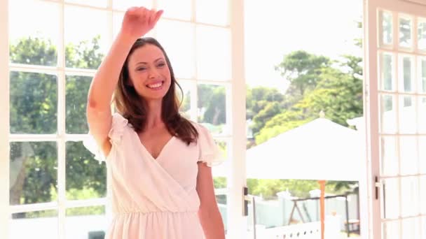 Mujer bonita entrando en un restaurante y saludando — Vídeos de Stock