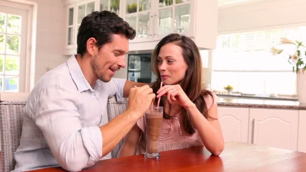 Pareja feliz bebiendo un batido juntos — Vídeos de Stock