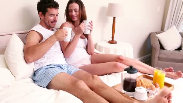 Ευτυχισμένο ζευγάρι τρώει πρωινό στο κρεβάτι — Αρχείο Βίντεο