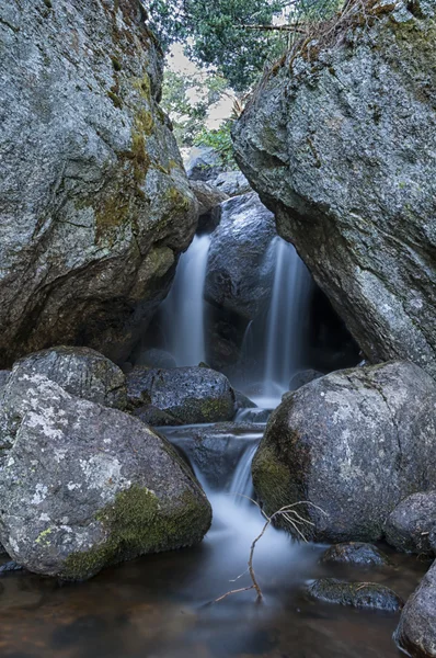Vattenfall inne i en grotta i skogen - lodrät — Stockfoto
