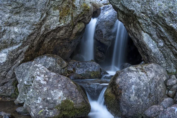 Vattenfall inne i en grotta i skogen — Stockfoto