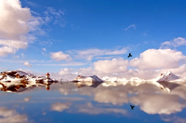 Reflejo de agua de las montañas nevadas y el faro — Foto de Stock