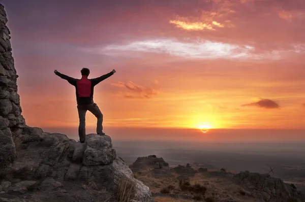 Człowiek na szczycie góry zwycięsko, podziwiając wschód słońca Obrazek Stockowy