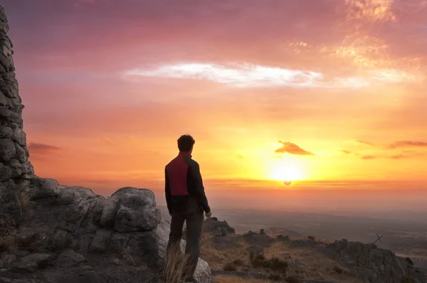 Homem no topo de uma montanha de pé contempla o amanhecer - 2 — Fotografia de Stock