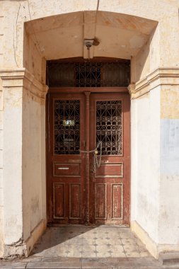 Zincirle kapatılmış ve derin taş deliğine kilitlenmiş eski bir ön kapı..