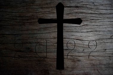 Eski ahşap arka planda Hıristiyan haçı silueti.