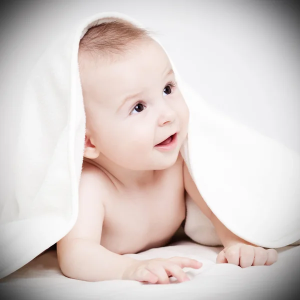 Happy baby under white blanket — Stock Photo, Image