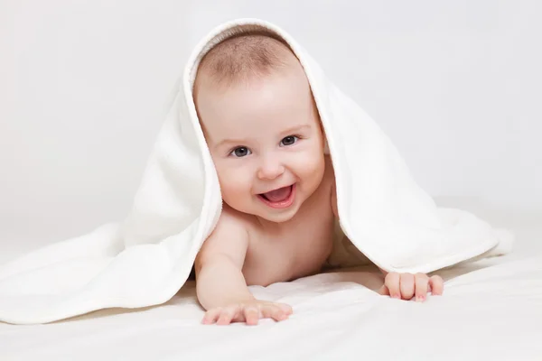 Mutlu bebek beyaz battaniye altında — Stok fotoğraf
