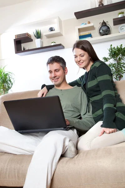 Jovem casal usando laptop — Fotografia de Stock