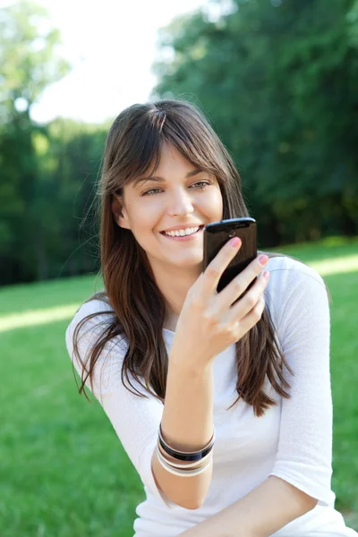 Ung kvinna som använder mobiltelefon — Stockfoto